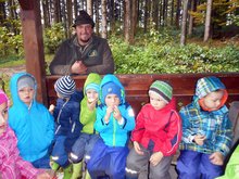 Foto (von Maria Schwamberger): Die Frankenburger Kindergartenkinder bei der gesunden Jause in der Waldhütte mit dem Jäger Dietmar Streicher